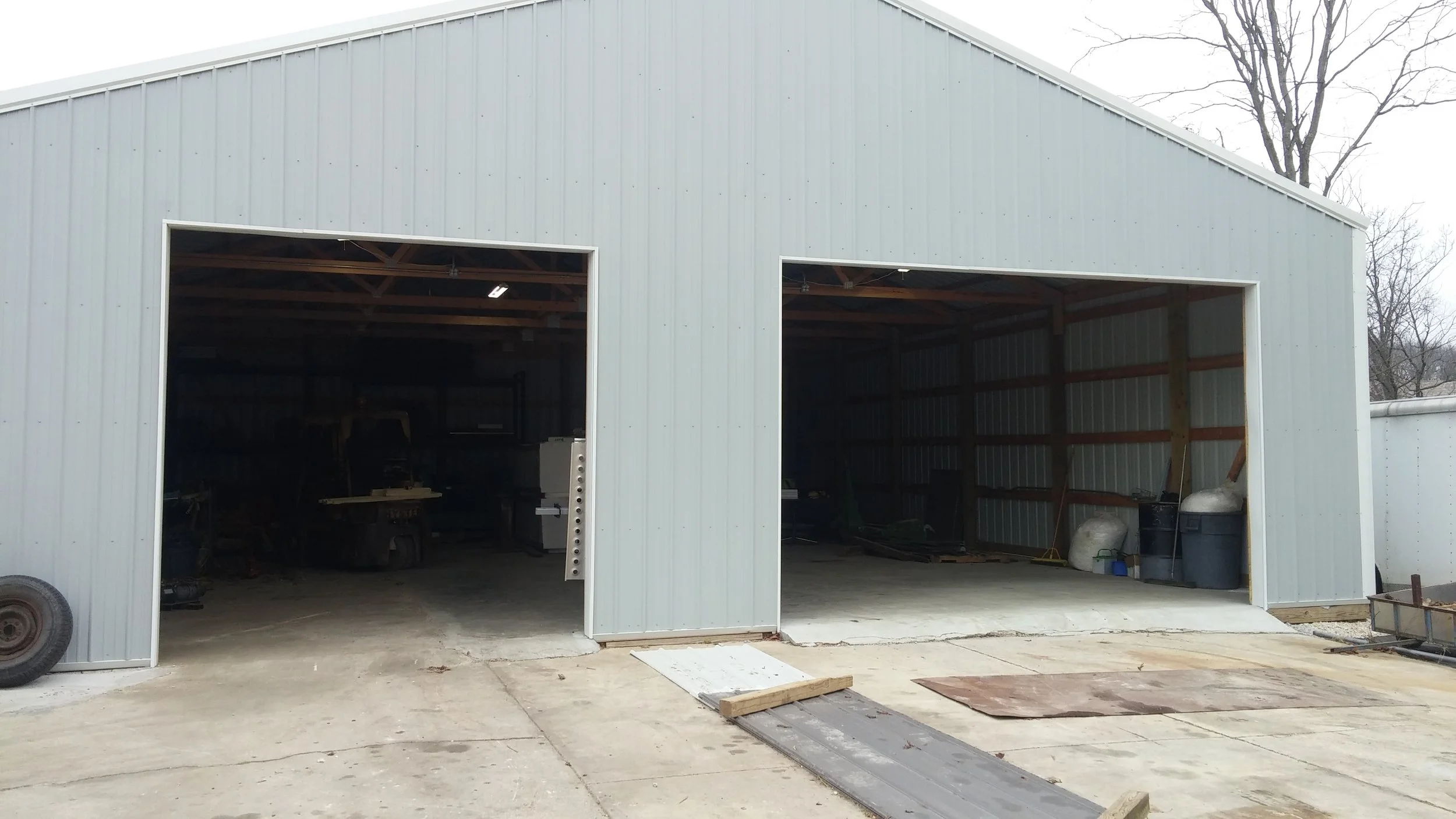 Commercial steel building with two open bays awaiting new sectional doors